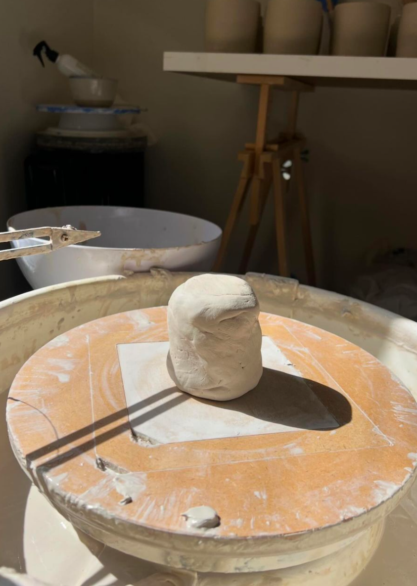 lump of clay about to become a mug on a pottery wheel